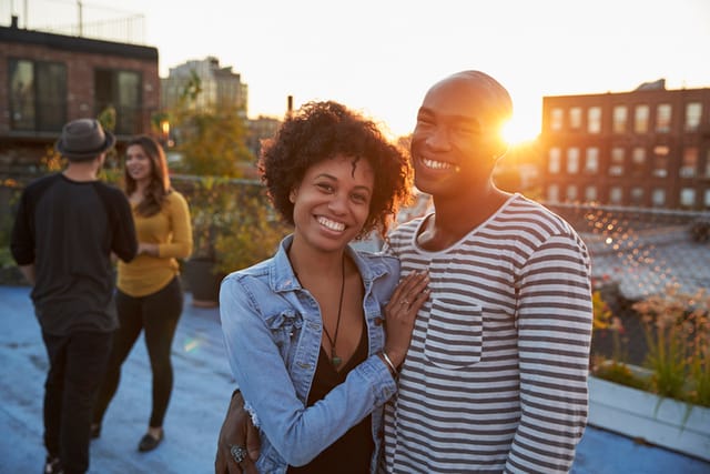 happy couple posing on sunset rooftop
