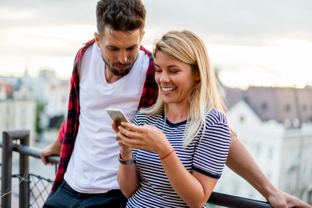 man reading woman's texts rooftop