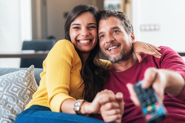 Happy couple watching tv.