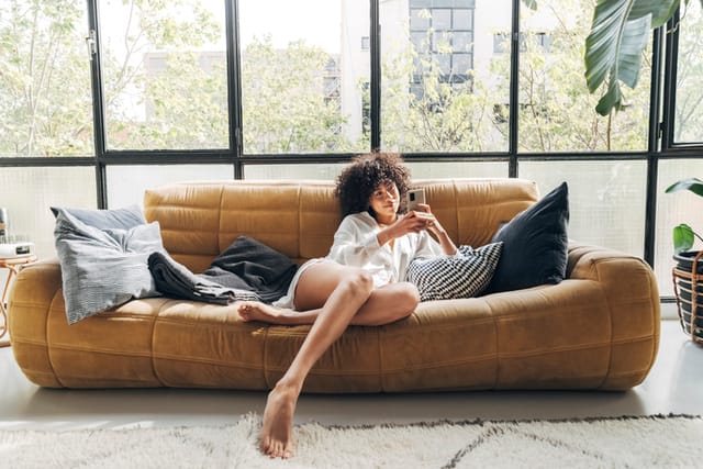 woman texting on couch