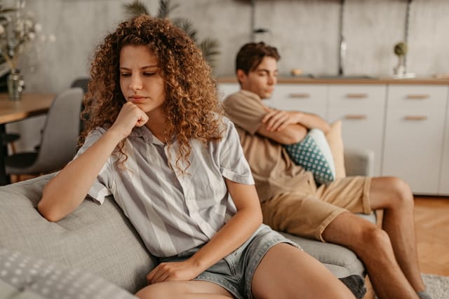unhappy couple arguing on couch