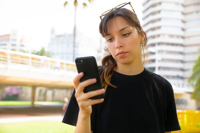 Woman seriously texting outside.