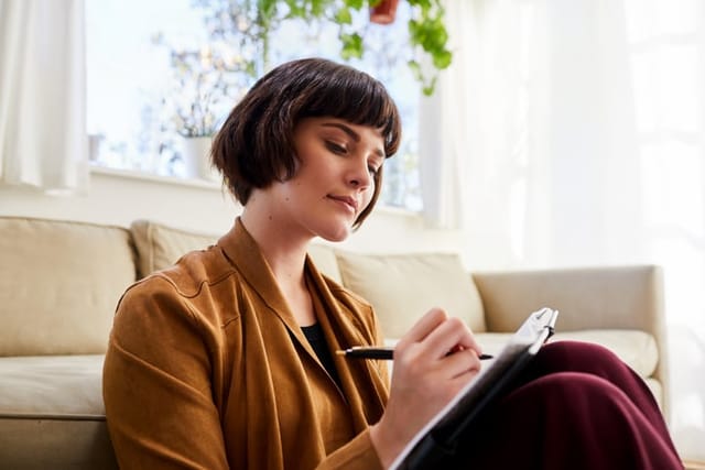millennial woman writing in journal
