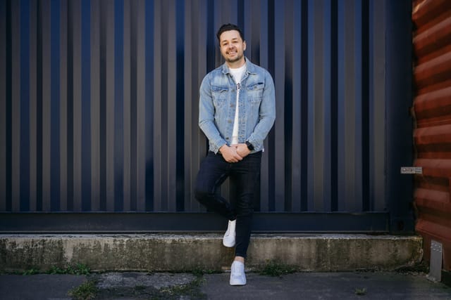 guy standing against wall outside