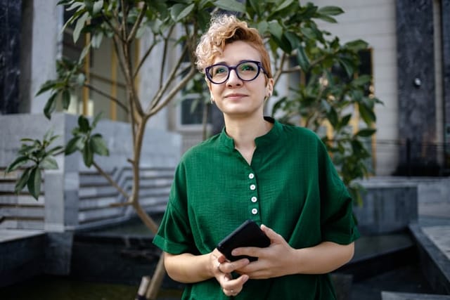 woman in green shirt looking into sky