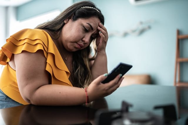 sad woman texting on phone