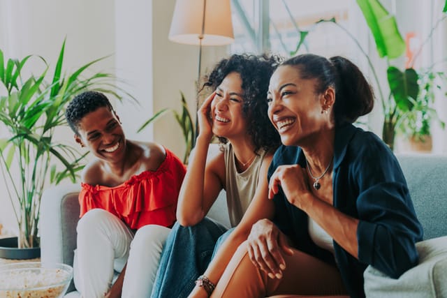 female friends laughing on couch