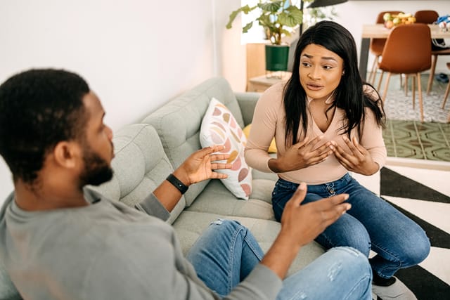 couple arguing on living room couch