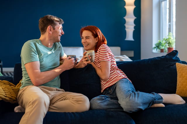 smiling couple chatting on sofa