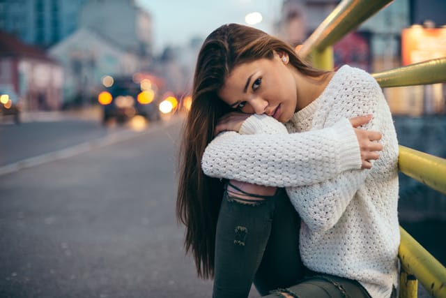 long hair woman white sweater on bench