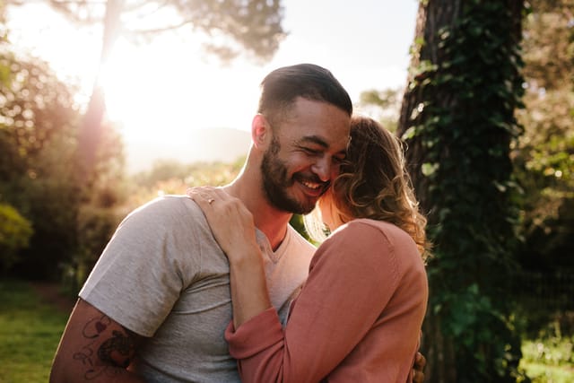 guy embracing girlfriend at park