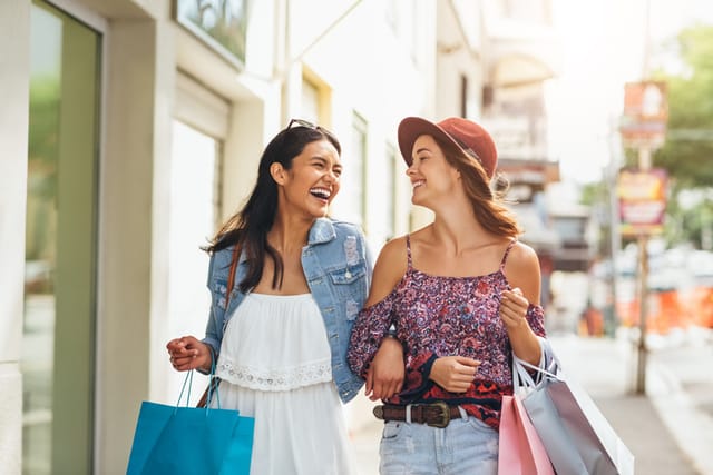 two friends laughing while shopping