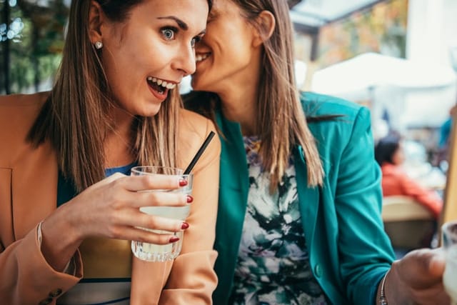two women gossiping over cocktails