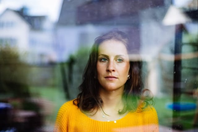 Young woman looks thoughtfully and sadly