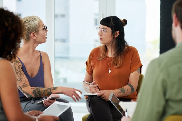 two female colleagues chatting during meeting