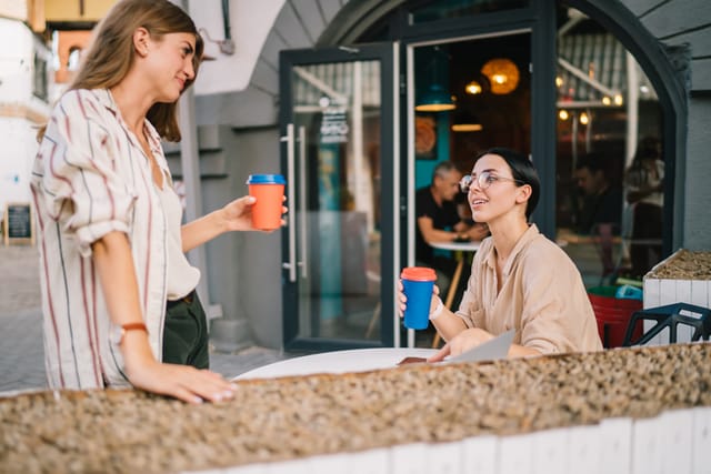 two friends having coffee outside