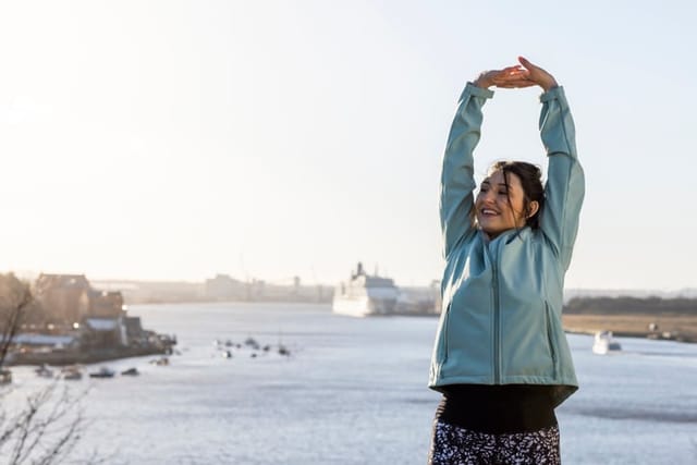 woman stretching outdoors in sunshine