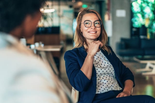 Middle aged businesswoman in a conversation with a colleague. Lawyer consulting client during formal meeting. Job interview and hiring process. Diverse colleagues discussing project concept