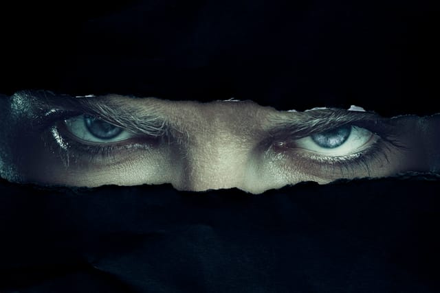 Angry man looking through a hole