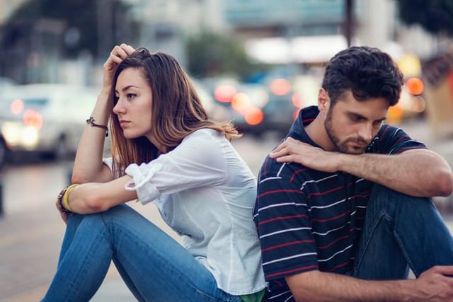unhappy couple sitting outside