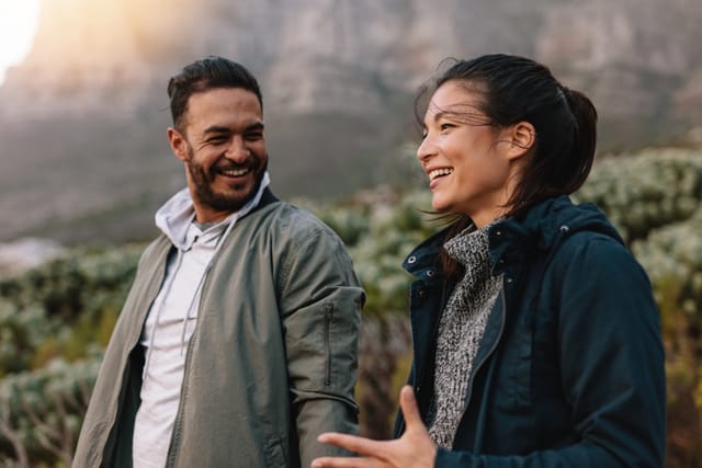 man and woman walking during hike