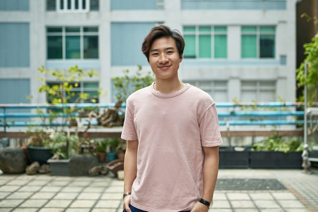 smliing young man with pink t-shirt