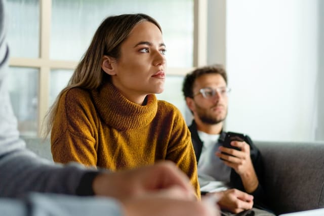 woman stares blankly at someone talking
