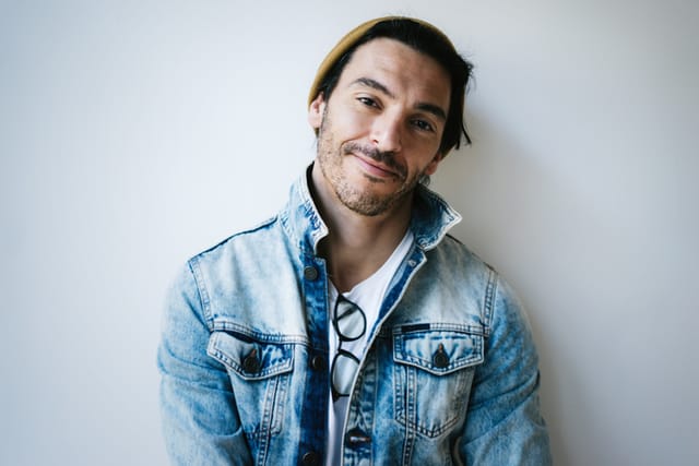smiling man standing against wall indoors