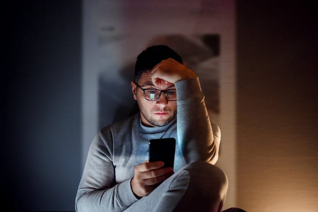 Man in the dark using social media.