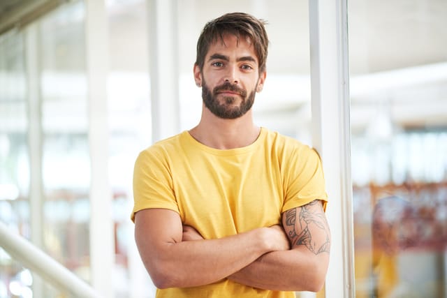 serious guy yellow t-shirt crossed arms