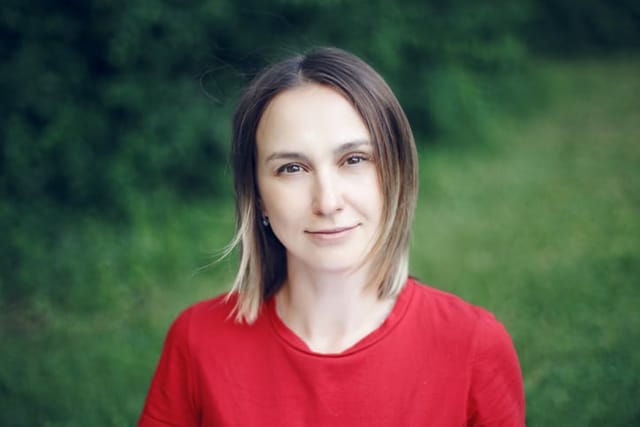 Portrait head shot of beautiful pensive Caucasian middle age woman with long light bob hair. Casual style real person in red t-shirt.