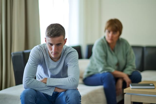 Mother talking with her upset son at home