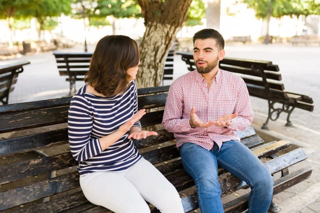 Relationship problems. Angry caucasian couple fighting and having a discussion while on a date in the park