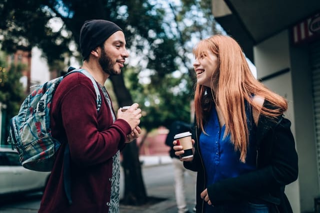 man and woman talking in park in autumn