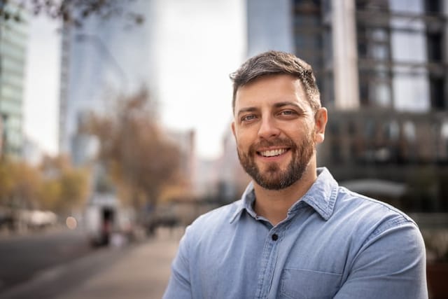 smiling bearded man with blue shirt