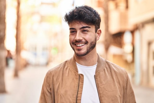 smiling young guy walking through town