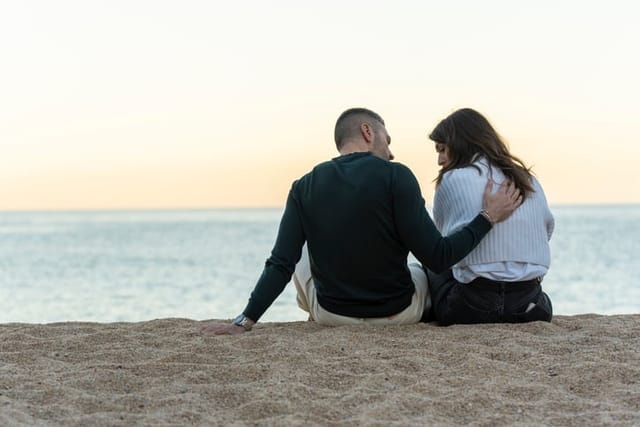 Friends sitting on the beach together.