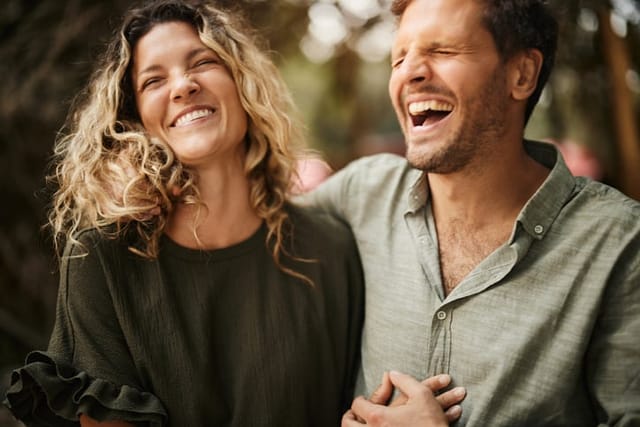 Carefree couple having fun while laughing and taking a walk in spring day.