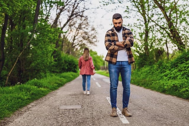 Couple is having difficulties in their relationship. Woman is leaving her man after argue. Conceptual image.