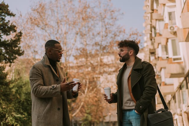 two men chatting on city street