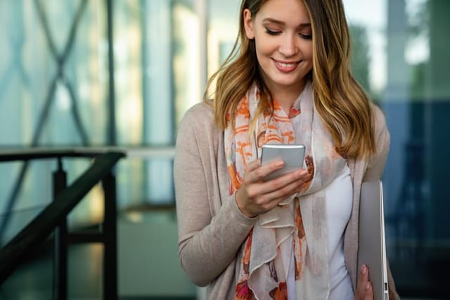 Business woman using mobile phone outdoors.