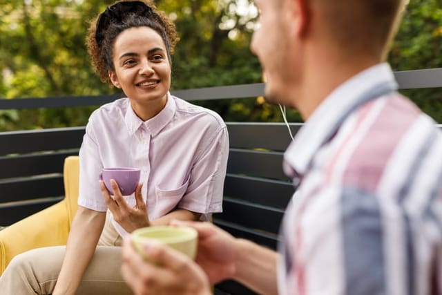 young man and woman chatting on park bench
