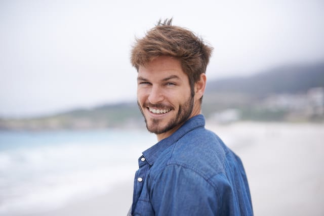 Shot of a young man enjoying a day at the beach