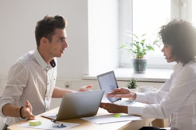 Multiracial colleagues argue about document disagree having conflict at work, diverse coworkers disputing about mistake in paperwork, african businesswoman blaming caucasian partner of bad contract