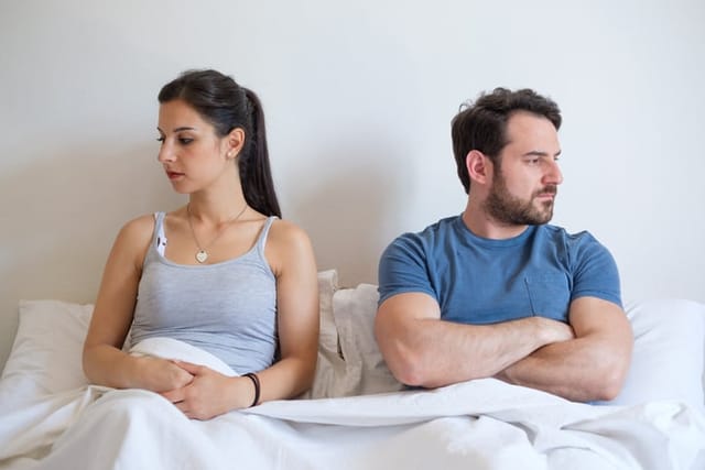 Couple having problem and arguing lying in bed.