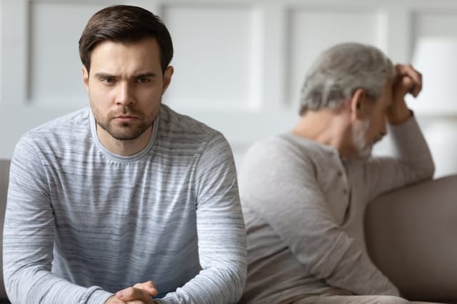 Unhappy grownup son feeling irritated after quarrel with dad.
