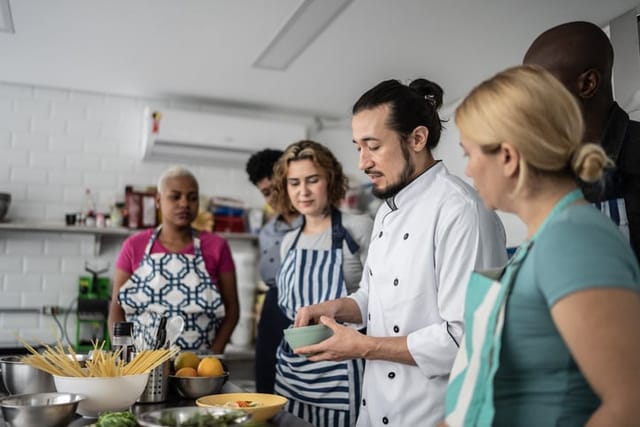 Chef giving instructions to students at cooking class.