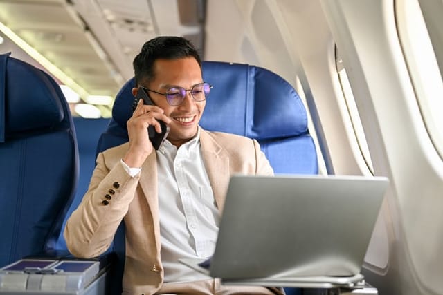 Businessman looking at his laptop screen on a flight.
