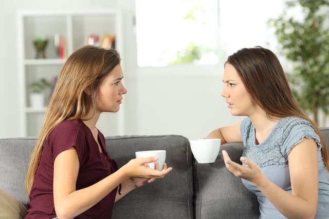 Two friends talking seriously at home.