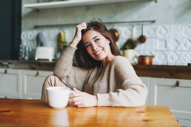 Woman cozy and happy to be staying in.